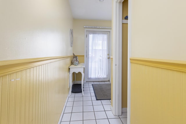 doorway to outside featuring light tile patterned floors and wooden walls