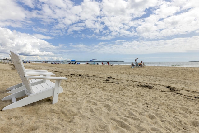 view of property's community featuring a water view and a beach view