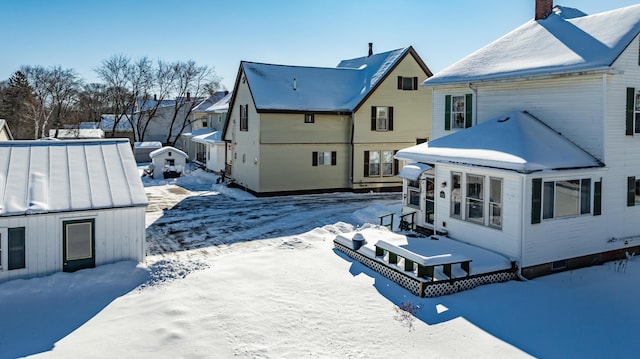 view of snow covered back of property