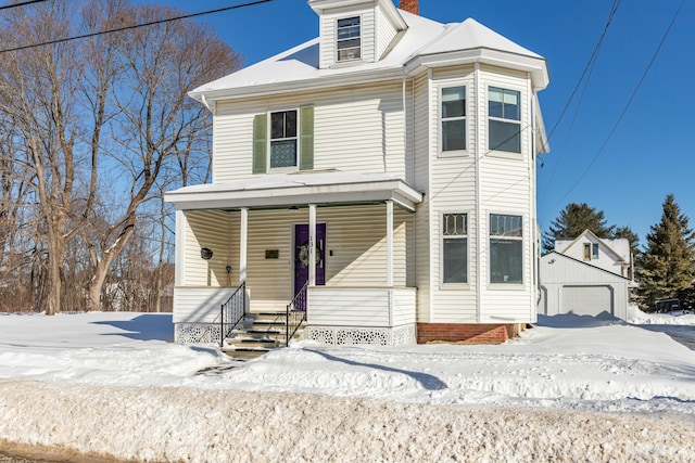 view of front of house featuring covered porch, a garage, and an outbuilding