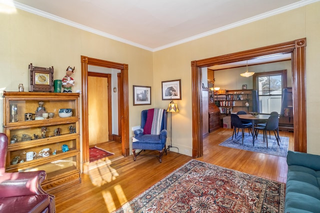 living area with ornamental molding and hardwood / wood-style floors