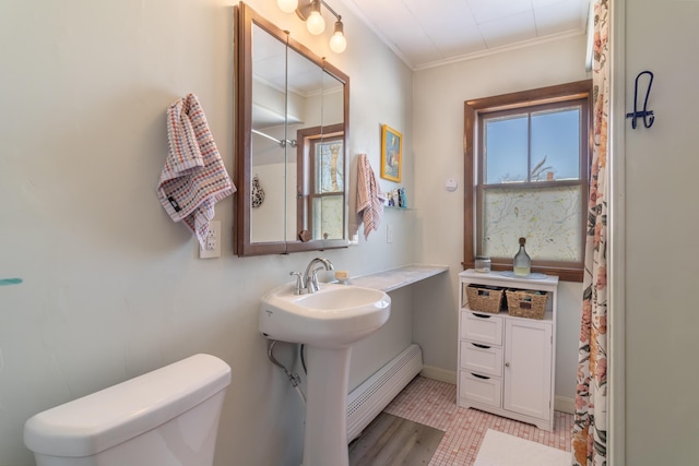 bathroom with crown molding, toilet, and a baseboard radiator