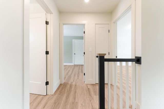 corridor with light wood finished floors and baseboards