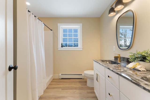 full bath featuring toilet, wood finished floors, vanity, baseboard heating, and a shower with curtain