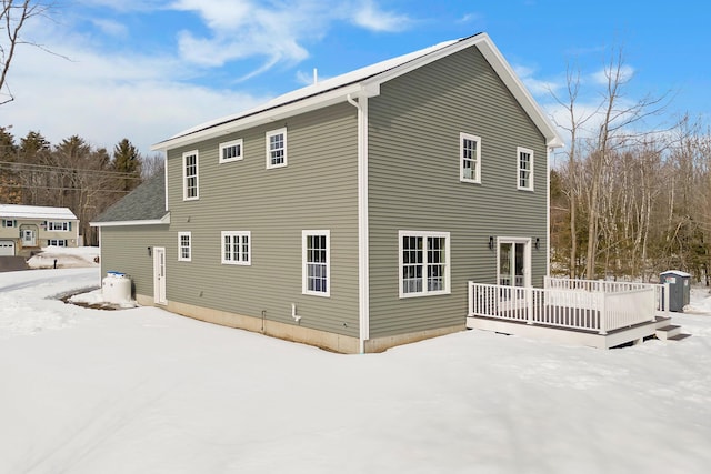 snow covered rear of property featuring a deck