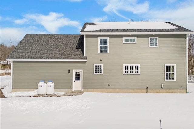 snow covered house with roof with shingles