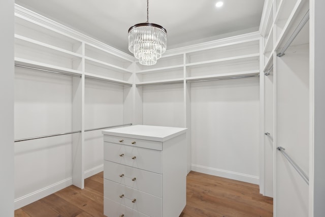 walk in closet featuring a chandelier and wood finished floors