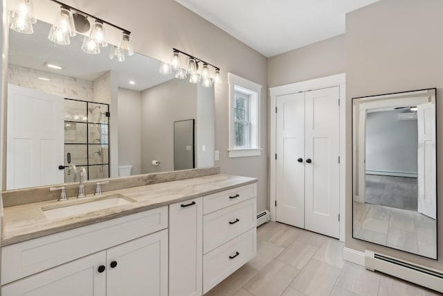 full bathroom with toilet, a shower stall, baseboard heating, and vanity