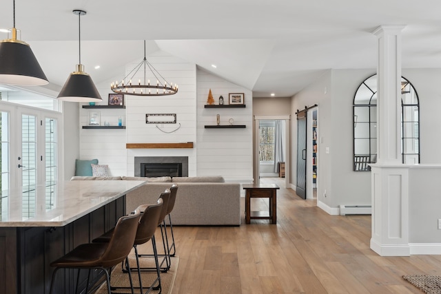 kitchen with a barn door, a baseboard radiator, vaulted ceiling, light wood-type flooring, and open shelves