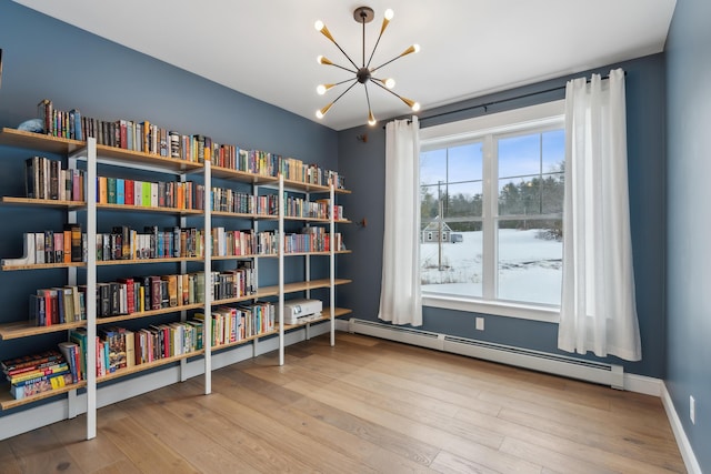 sitting room with baseboards, a notable chandelier, baseboard heating, and wood finished floors