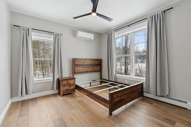 bedroom with a baseboard radiator, hardwood / wood-style flooring, baseboards, and a wall mounted AC