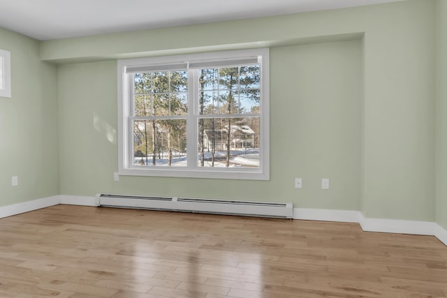 empty room with light hardwood / wood-style floors and baseboard heating