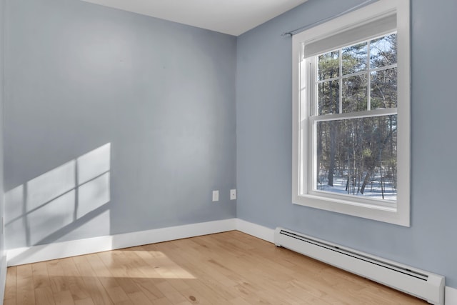 empty room with light hardwood / wood-style flooring and a baseboard radiator