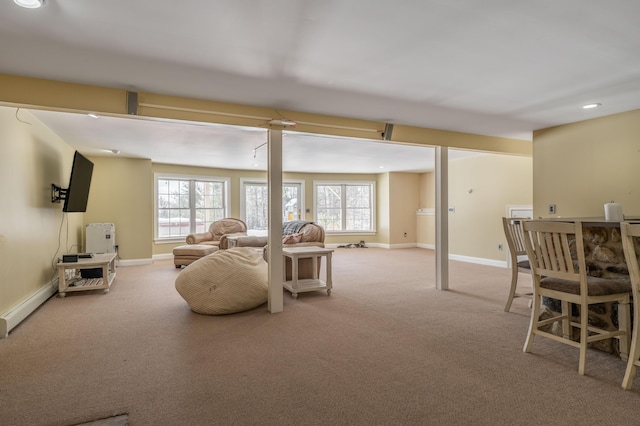 carpeted living room featuring a baseboard heating unit and plenty of natural light