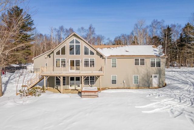 snow covered house with a wooden deck