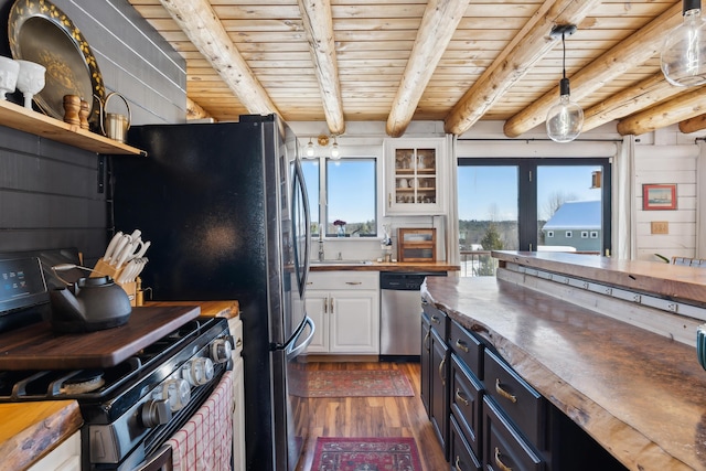 kitchen featuring butcher block countertops, dishwasher, white cabinets, hanging light fixtures, and gas range