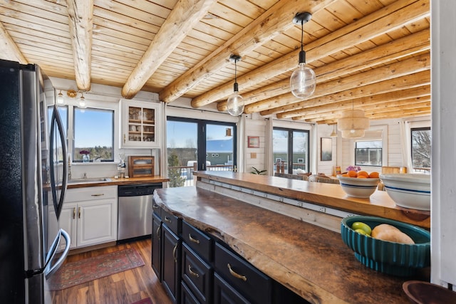 kitchen featuring butcher block countertops, stainless steel dishwasher, white cabinets, and refrigerator