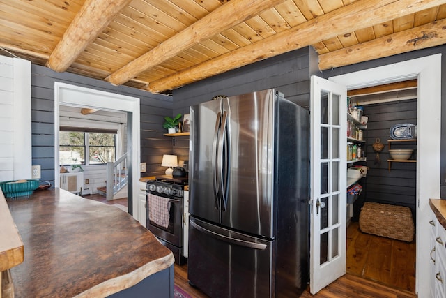 kitchen featuring appliances with stainless steel finishes, dark hardwood / wood-style floors, beamed ceiling, white cabinets, and wood ceiling