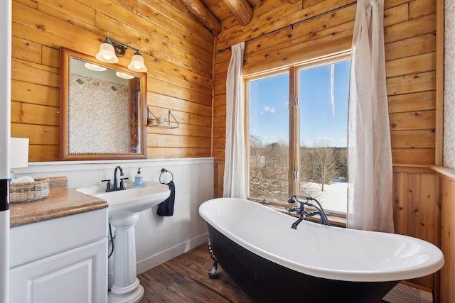 bathroom featuring hardwood / wood-style flooring, a washtub, and wood walls