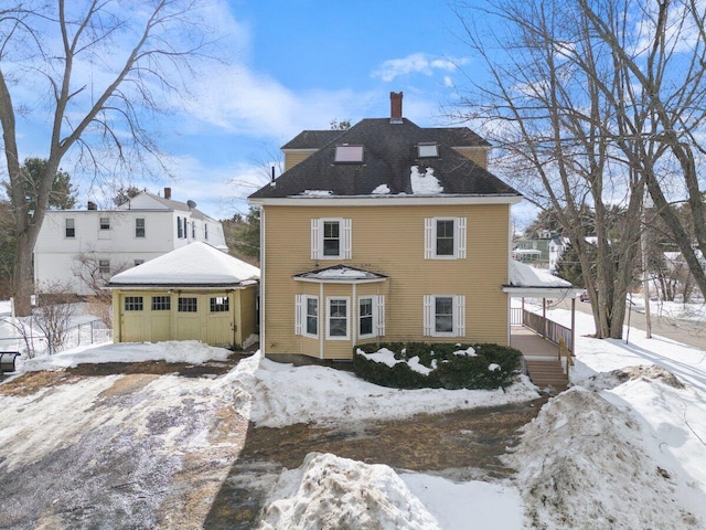 view of front facade featuring an outdoor structure and a chimney