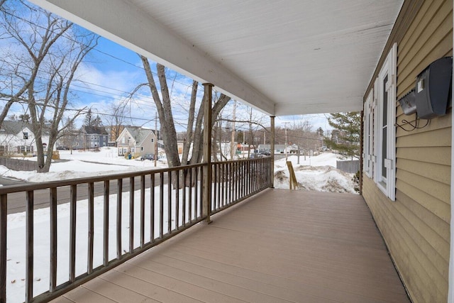 snow covered deck with a residential view