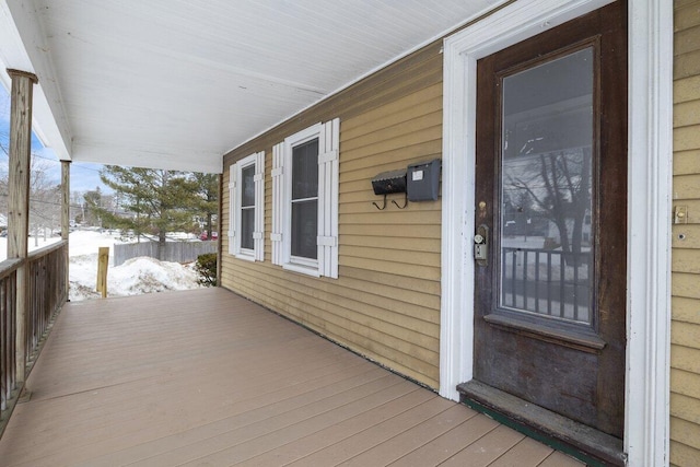 snow covered deck with a porch