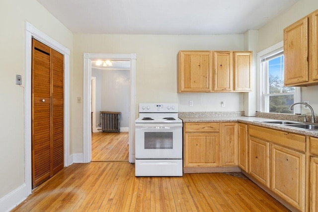 kitchen featuring light brown cabinetry, radiator heating unit, electric stove, and a sink