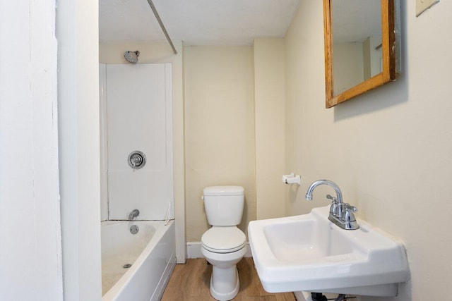 bathroom featuring a sink, toilet, wood finished floors, and washtub / shower combination