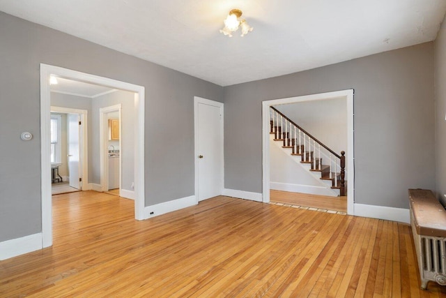 unfurnished living room featuring baseboards and light wood finished floors