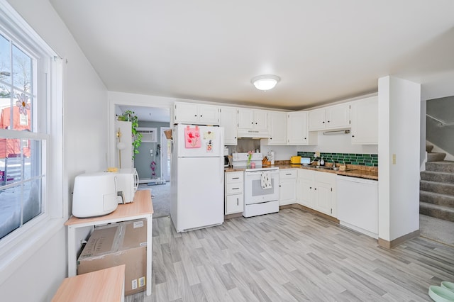 kitchen featuring white cabinetry, white appliances, light hardwood / wood-style floors, and sink