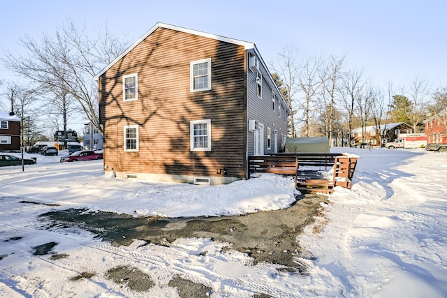 view of snowy exterior with a wooden deck