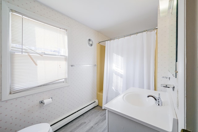 full bathroom featuring baseboard heating, vanity, wood-type flooring, toilet, and shower / bath combo with shower curtain