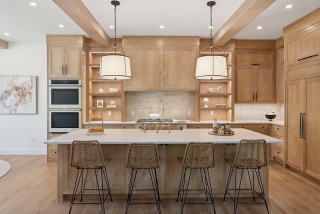 kitchen featuring decorative light fixtures, stainless steel appliances, a large island, and beamed ceiling