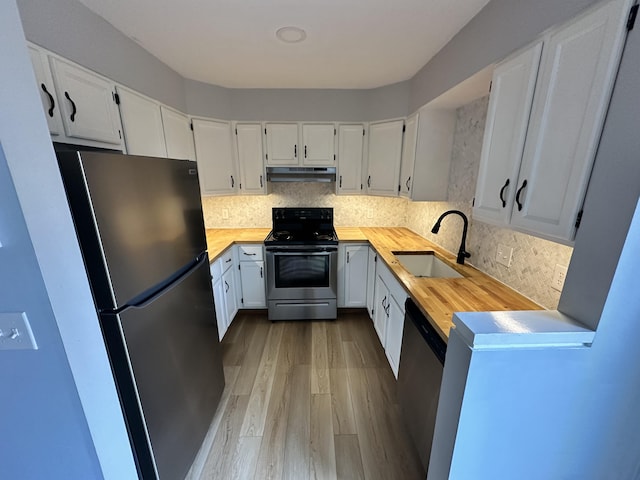 kitchen with white cabinets, wooden counters, appliances with stainless steel finishes, and sink