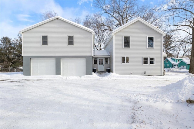 snow covered house with a garage