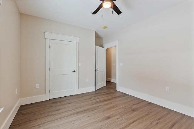 unfurnished bedroom with ceiling fan and light wood-type flooring