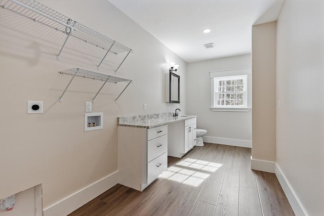 washroom featuring sink, hookup for a washing machine, electric dryer hookup, and light hardwood / wood-style flooring