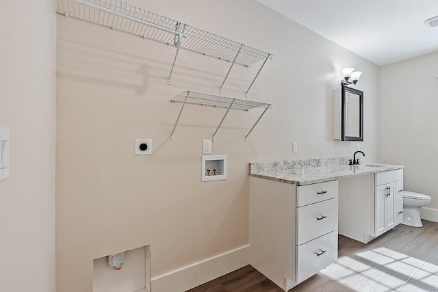 laundry area with sink, hookup for an electric dryer, hookup for a washing machine, and light hardwood / wood-style floors