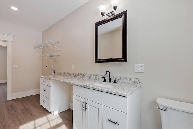 bathroom featuring toilet, vanity, and wood-type flooring