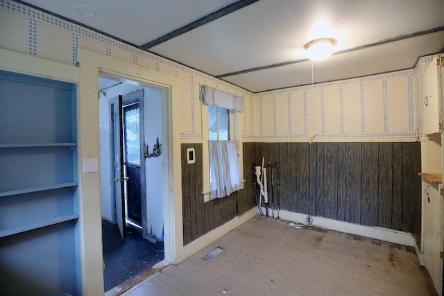 spare room featuring hardwood / wood-style flooring and wood walls