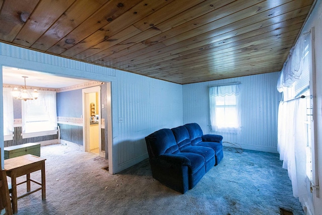 sitting room with an inviting chandelier, carpet, and wooden ceiling