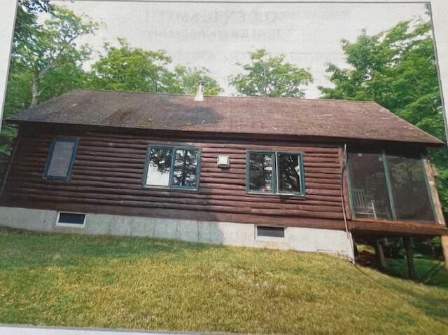 45 Dickson Rd, Carrying Place Town Twp, ME 04961 - view of home's exterior with log exterior, a sunroom, and a lawn