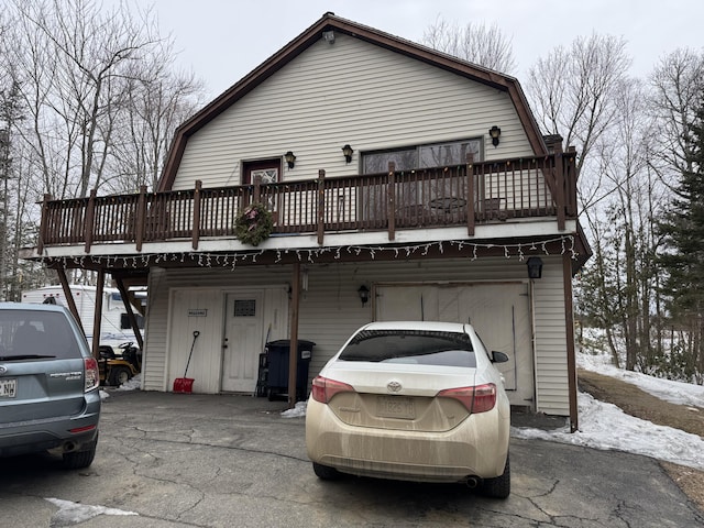 view of front facade featuring aphalt driveway and a gambrel roof