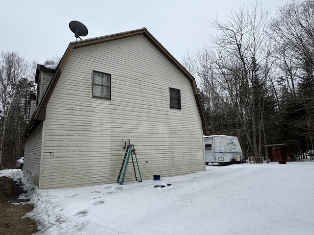 view of snow covered exterior featuring a gambrel roof