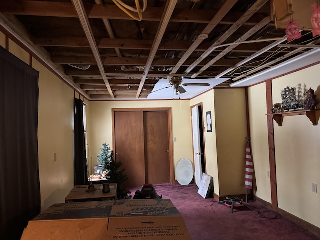 below grade area with carpet floors and a ceiling fan