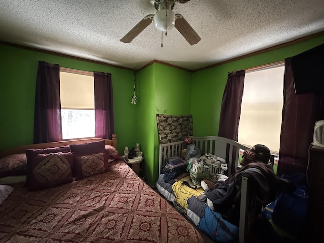 bedroom with ceiling fan, crown molding, and a textured ceiling