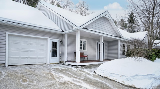 ranch-style home with a porch, an attached garage, and driveway