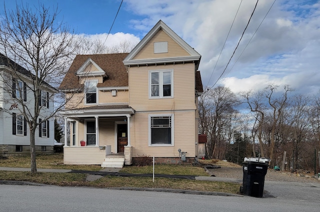 view of front of house featuring roof with shingles and a porch