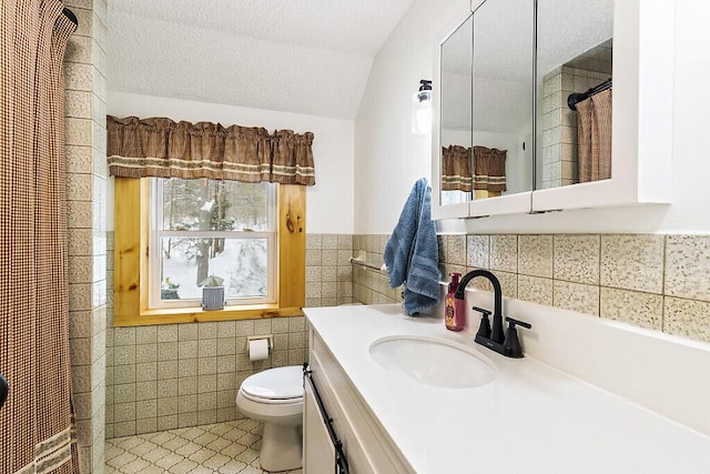 bathroom featuring a textured ceiling, toilet, tile walls, and vanity