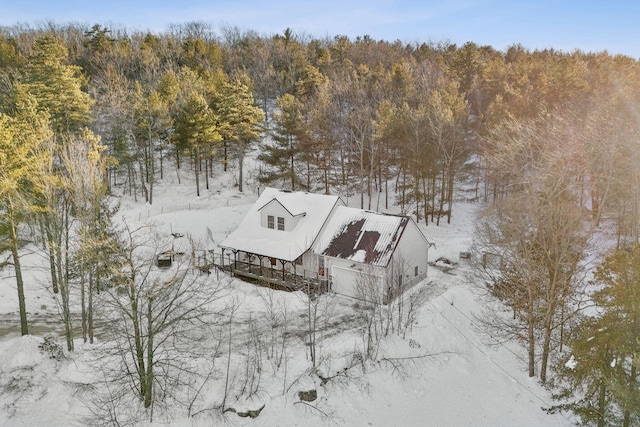 snowy aerial view with a wooded view